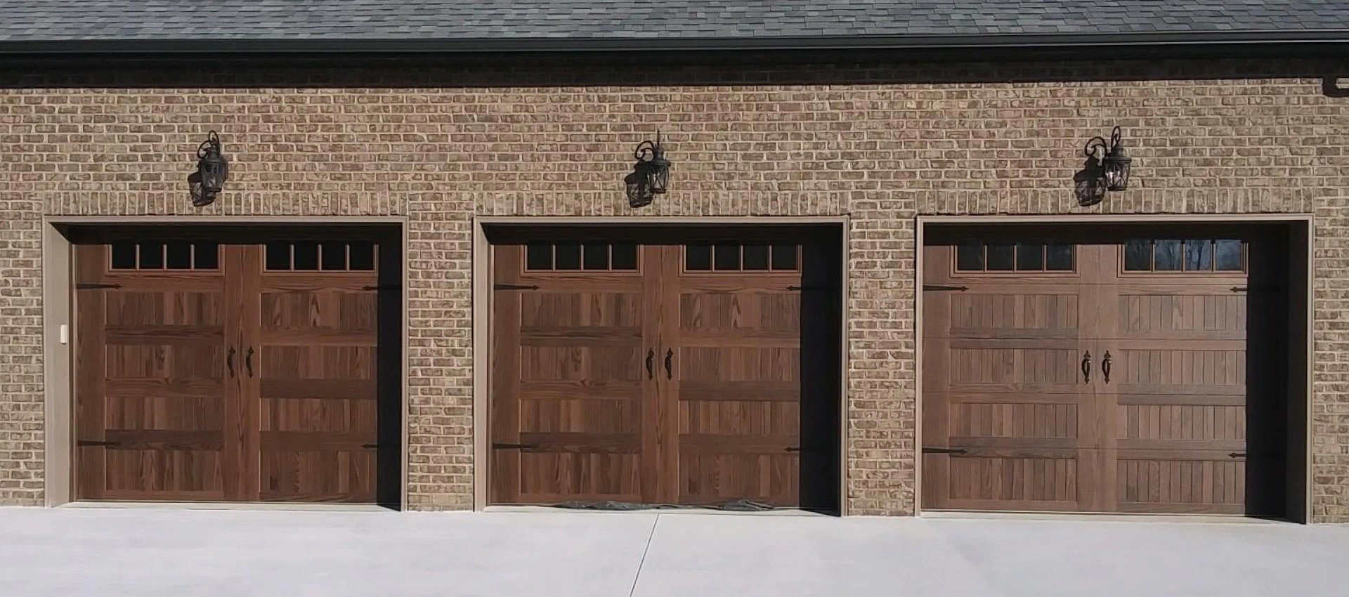 triple garage door installed in a brick residential house